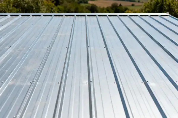 Toiture en bac acier grise avec paysage verdoyant en arrière-plan sans nuages